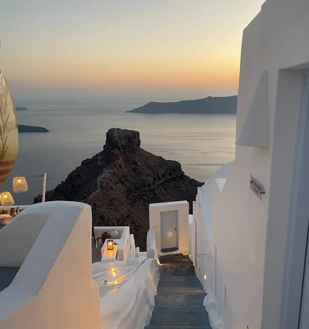 Whitewashed steps leading down towards the sea at sunset