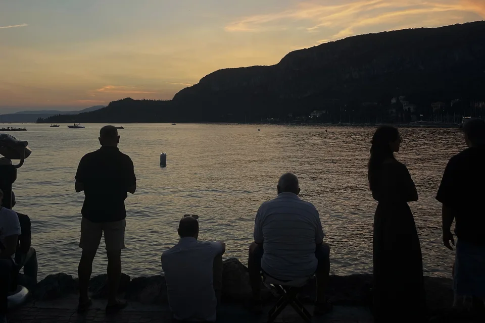 People watching the sunset over the lake from the rocks